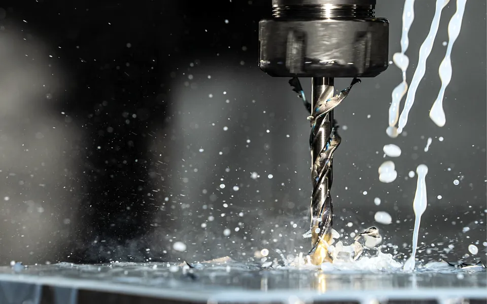 CNC machine drilling metal with coolant spraying