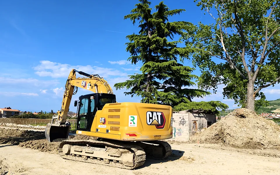 Excavator working on a construction site under a blue sky