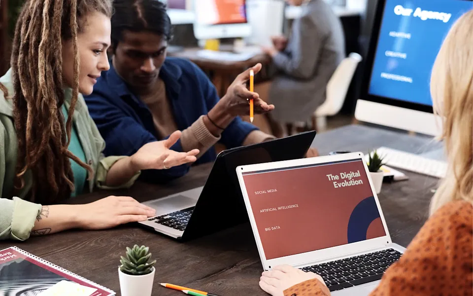 Agency team reviewing a client presentation together on laptops