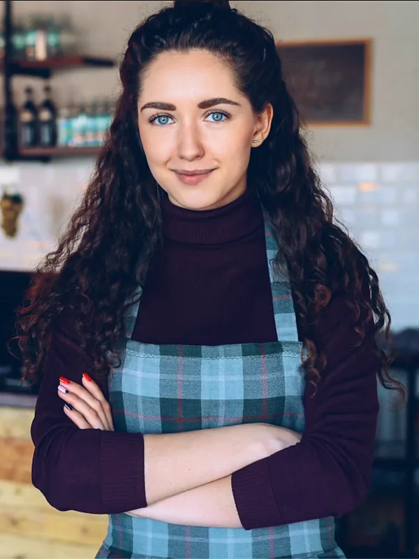 Café owner standing confidently inside her coffee shop